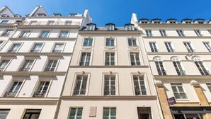 A multi-story building with a classic European architectural style, featuring symmetrical windows and balconies. - ELEGAN PARISIAN APARTMENT-LUXURY,COMFORT & SPECTACULAR VIEWS AWAIT– RUE MONSIGNY (Paris)