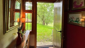 Eine Holztür, die in einen Garten mit Blick auf Bäume und Gras führt.
