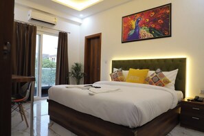 A hotel room with a large bed, a painting of a peacock, and a view of the outdoors. - Opulent Inn By Lime Tree Hotels (Greater Noida)
