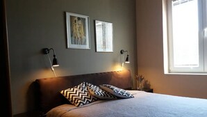 A bedroom with a bed, two wall-mounted lamps, and two framed artworks. - Apartments Villa Dona (Vela Luka)