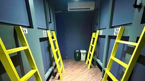A room with wooden flooring, yellow ladders, and a ceiling fan. - Shinjuku Nikka Hotel - Hostel  (Tokyo)