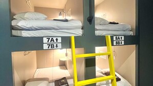 A set of bunk beds with labels 7A and 8A, a yellow ladder, and a small table with a lamp. - Shinjuku Nikka Hotel - Hostel  (Tokyo)