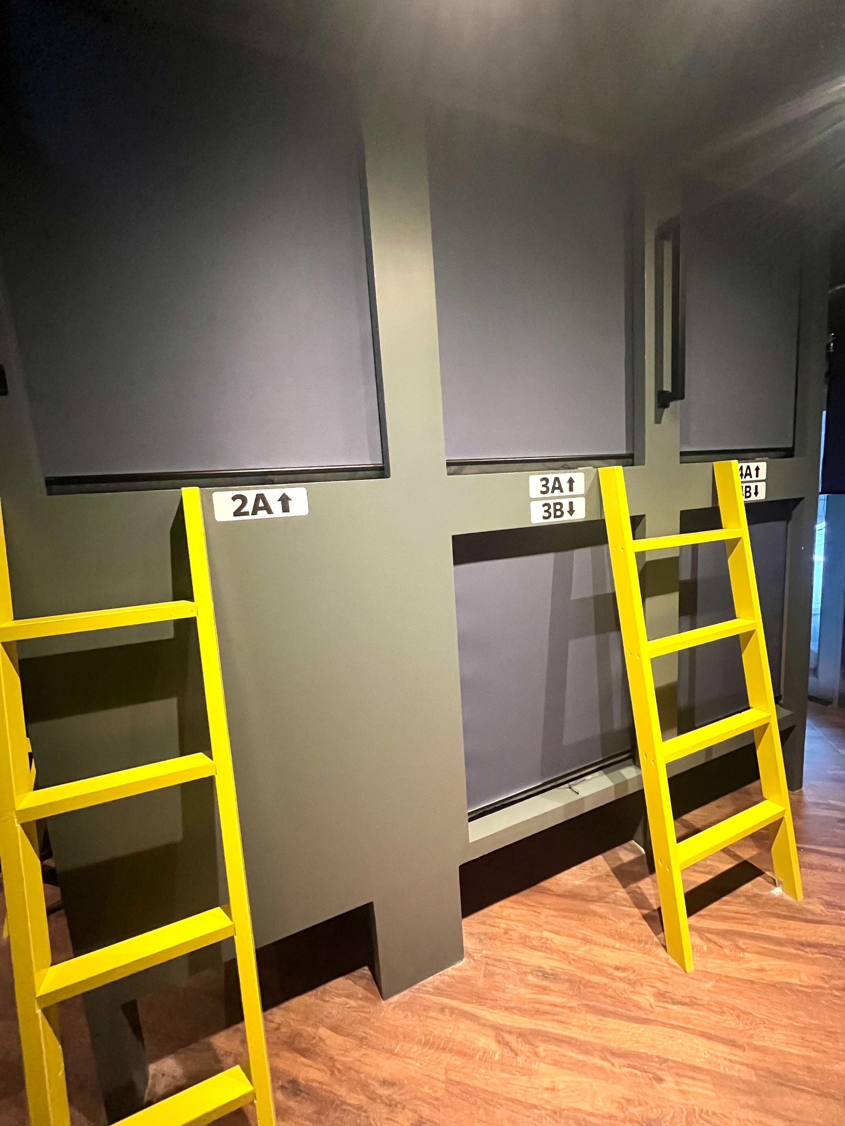 A room with two yellow ladders, each with a sign indicating directions to different areas.