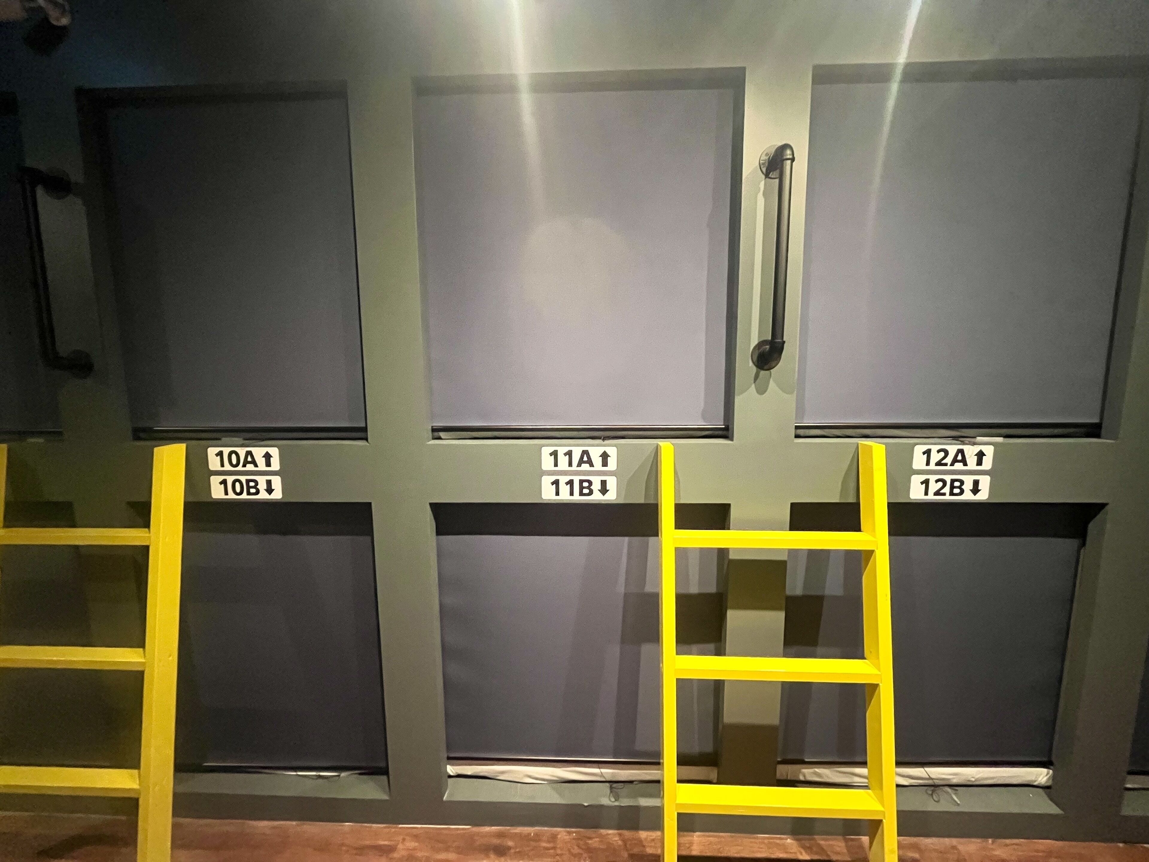 A row of closed doors with labels indicating room numbers and directions for access.