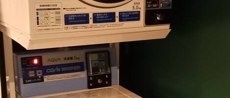Una lavadora de monedas con panel de control y una pantalla pequeña.