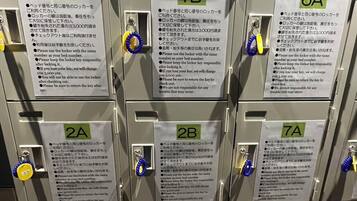 A row of metal lockers with numbered labels and instructions in Japanese.