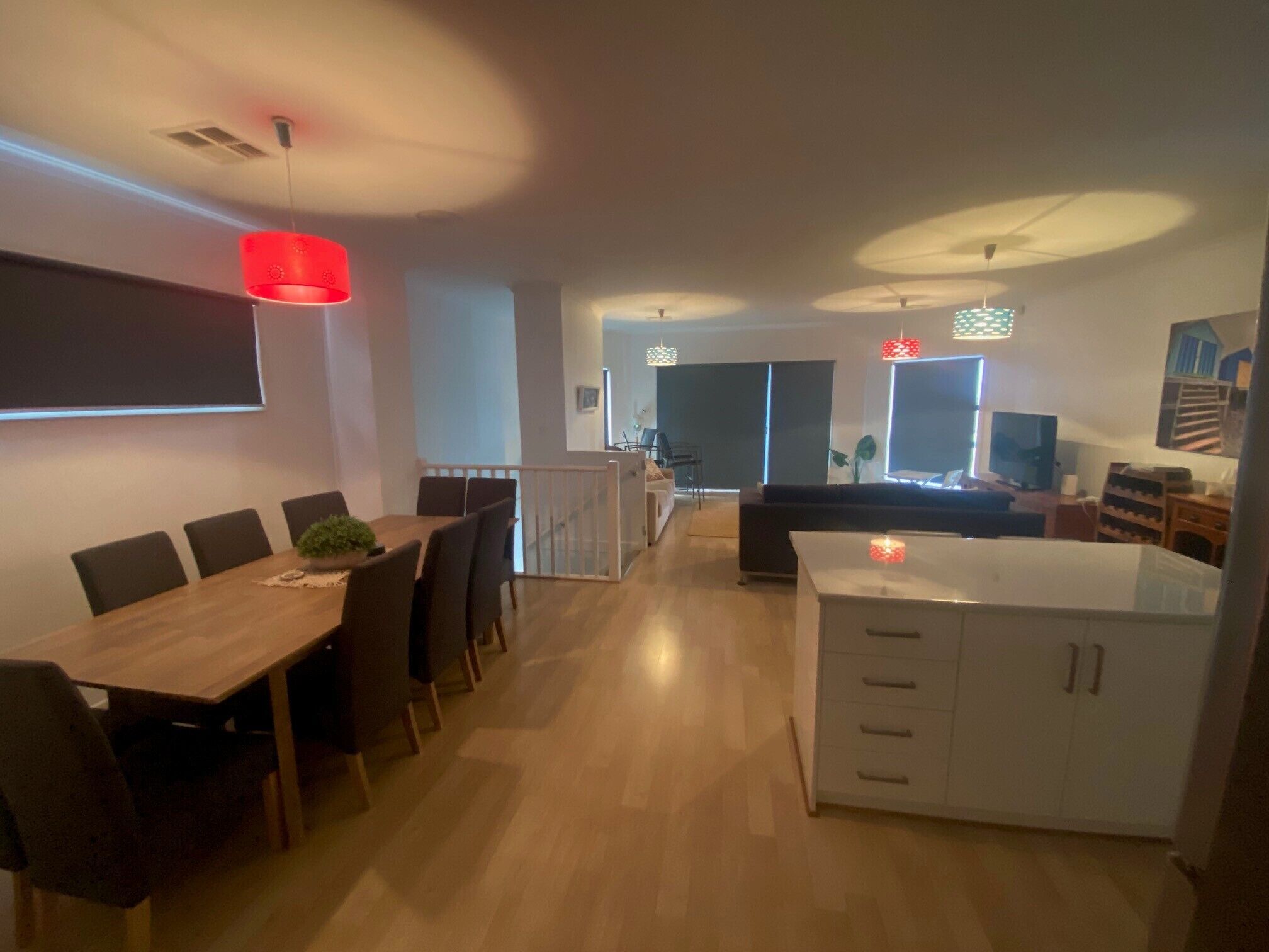 A modern living space with a dining area, kitchen, and seating area.