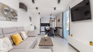 A modern living room with a sofa, coffee table, and a flat-screen TV. - Villa Corichi (Opatija)