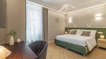 A hotel room with a bed, bedside table, lamp, chair, and a window with curtains.