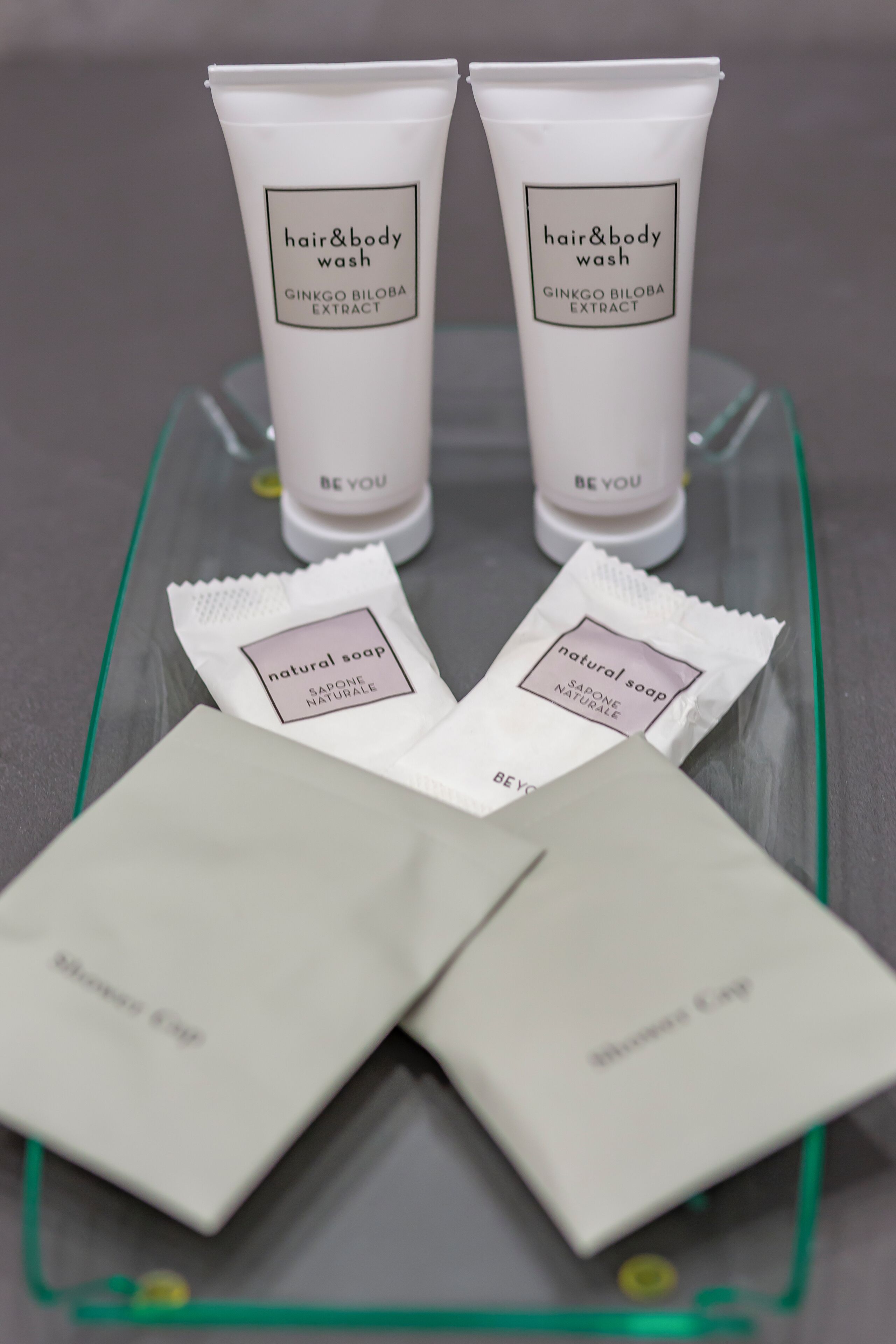 Two tubes of hair and body wash and two packets of natural soap on a clear tray.
