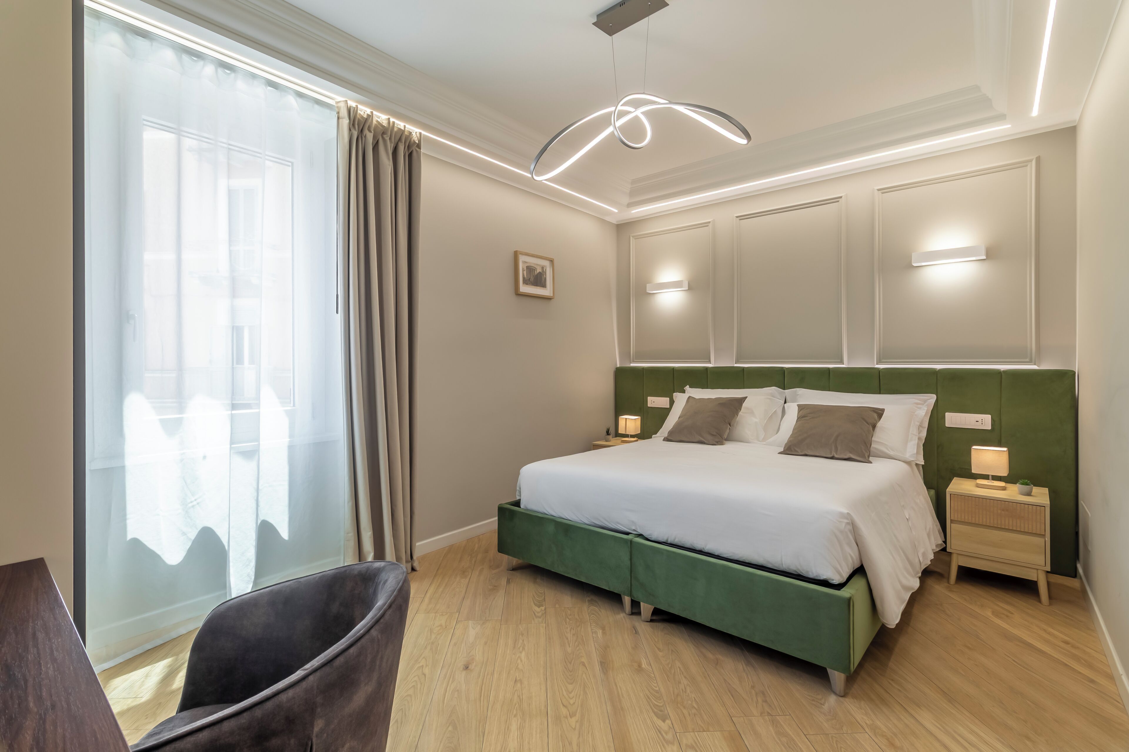 A bedroom with a bed, bedside tables, a chair, and a window with curtains.