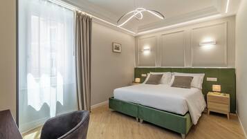 A bedroom with a bed, bedside tables, a chair, and a window with curtains.