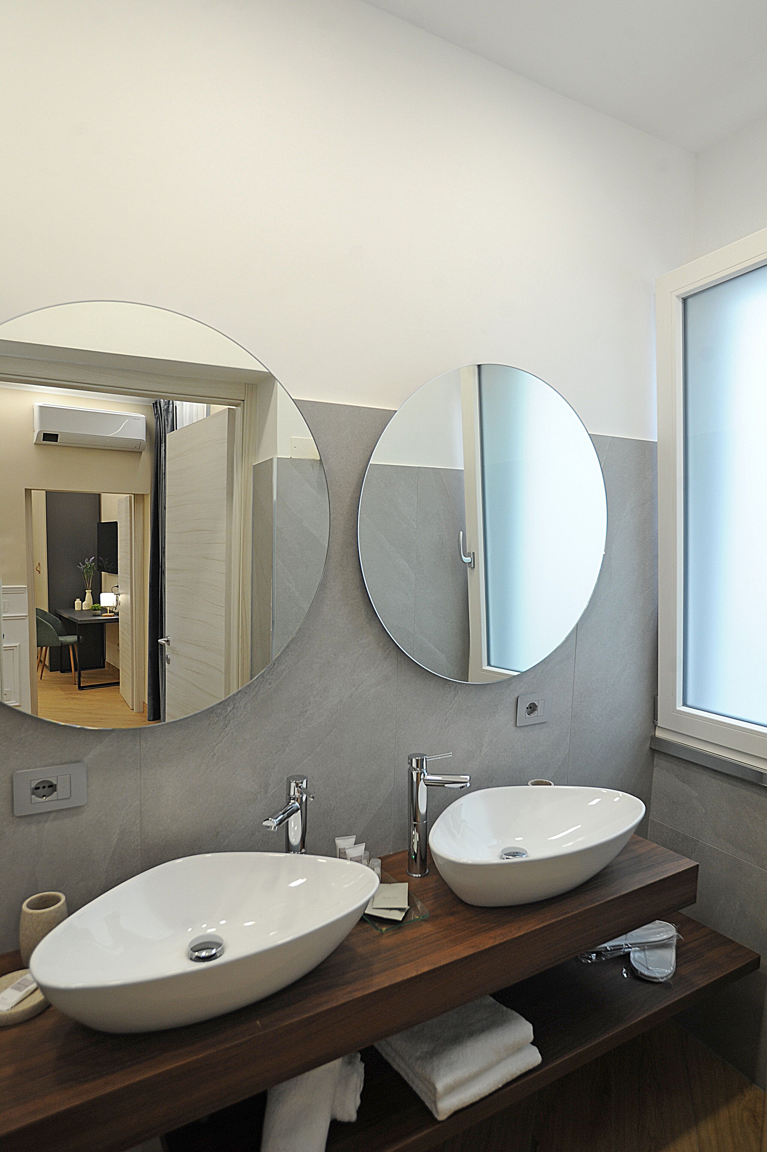 A bathroom with two sinks, a mirror, and a window.