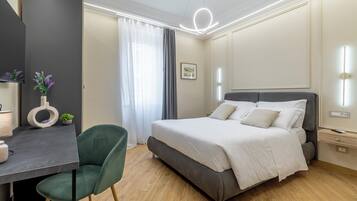 Una camera da letto moderna con un letto, una scrivania, una sedia e uno specchio.
