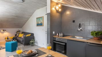 A modern kitchen with a built-in oven, a sink, and a wooden countertop.