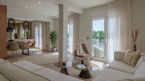 Un amplio salón con sofá, una mesa de centro y una zona de comedor con sillas y una mesa.