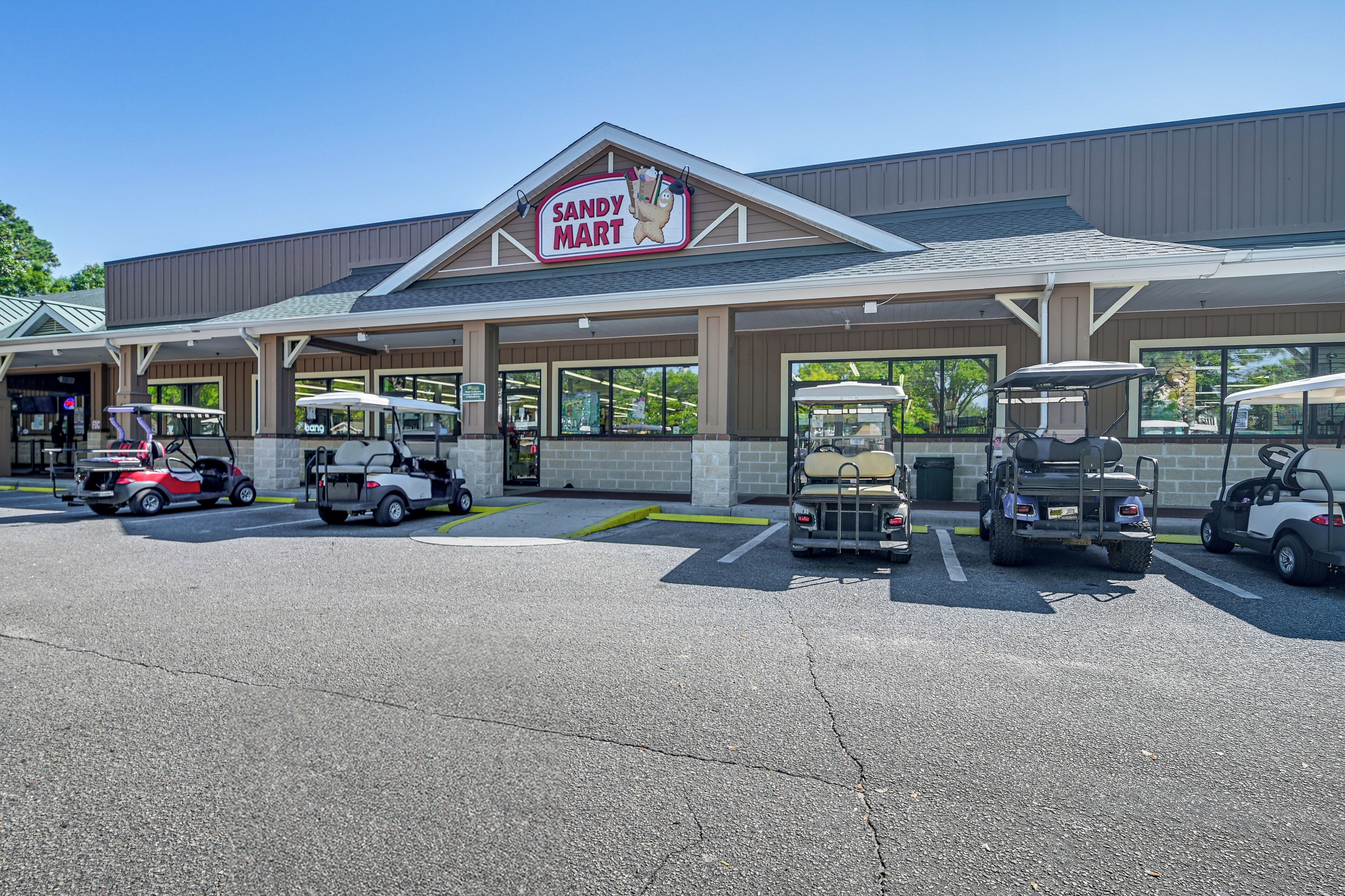 A Sandy Mart store with a parking lot containing golf carts and a golf cart rental service.