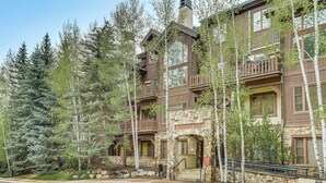 A multi-story lodge with stone and wood exterior, balconies, and a stone entrance. - Walk to Lift: Arrowhead Ski Condo w/ Pool Access! (Edwards)