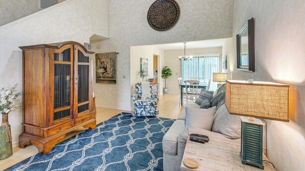 A spacious living room with a large wooden cabinet, a patterned rug, a sofa, and a lamp. - Convenient St Simons Island Home - 3 Mi to Beach! (St. Simons Island)