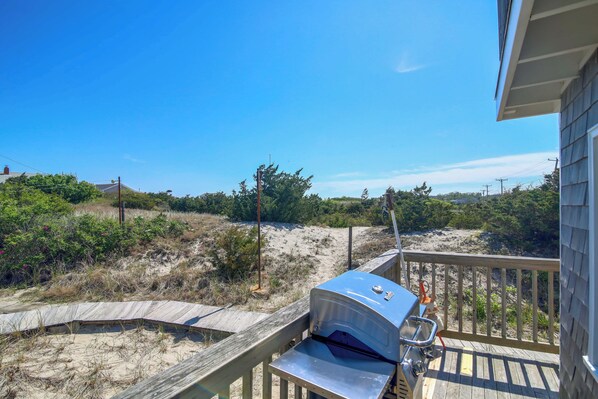 A deck with a barbecue grill overlooking a sandy beach and dunes. - Steps to the Sand! Plymouth Beach Cottage (Plymouth)