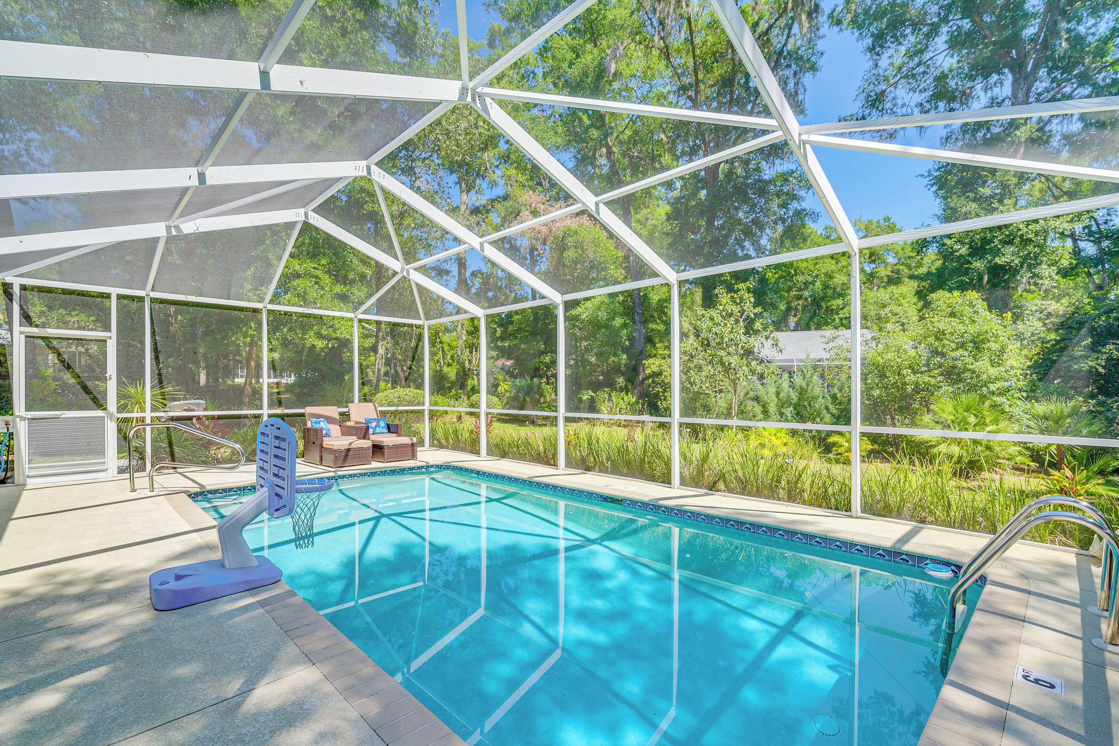 Una piscina coperta con tetto in vetro, immersa nel verde.