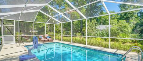 Una piscina coperta con tetto in vetro, immersa nel verde.