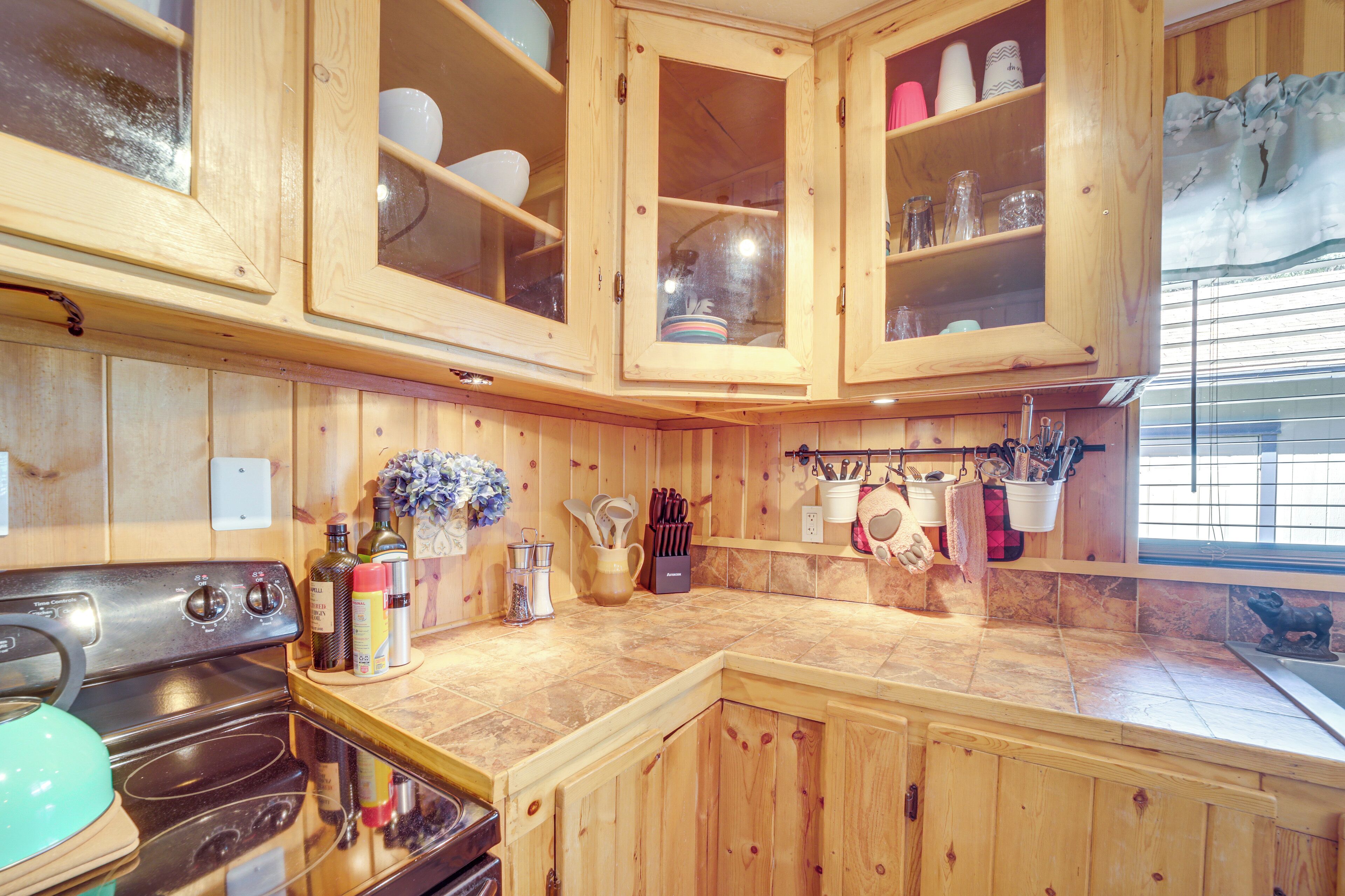 Een houten keuken met kastjes, een fornuis en verschillende keukengerei.