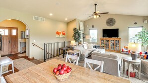 A spacious living room with a dining area, a staircase, and a television. - Spearfish Retreat w/ Fireplace + Mountain Views! (Spearfish)