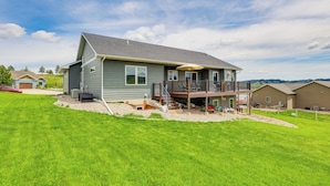 A two-story house with a balcony, a covered patio, and a well-maintained lawn. - Spearfish Retreat w/ Fireplace + Mountain Views! (Spearfish)