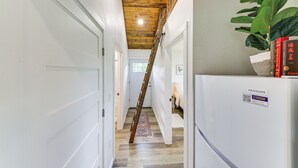 Un couloir avec un plafond en bois, un réfrigérateur et une plante.