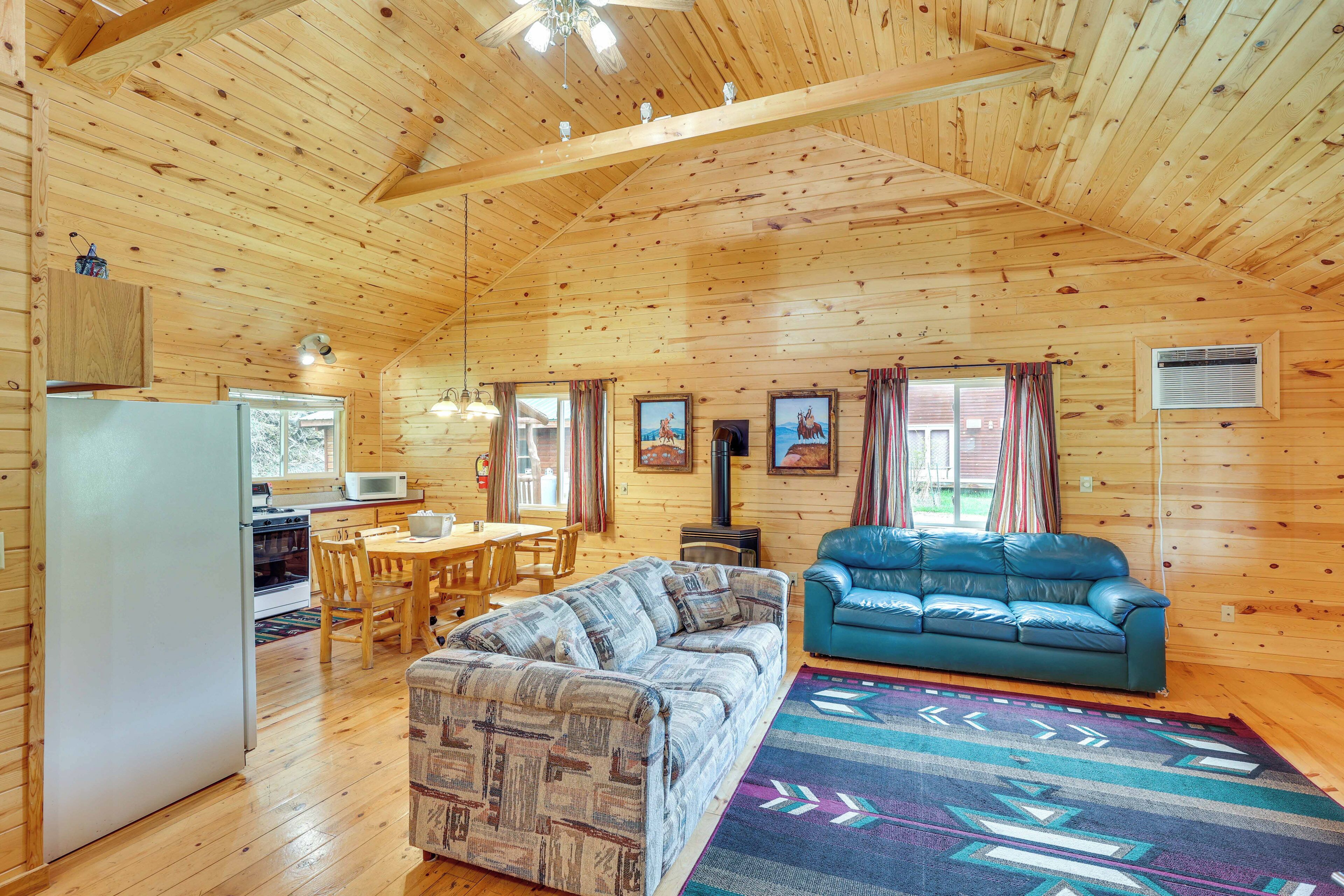 Interior de una cabaña de madera con cocina, comedor y sala de estar.
