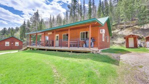 A lodge with a covered porch and multiple rooms, surrounded by a forested area. - Wraparound Deck & Grill: Deadwood Cabin (Deadwood)