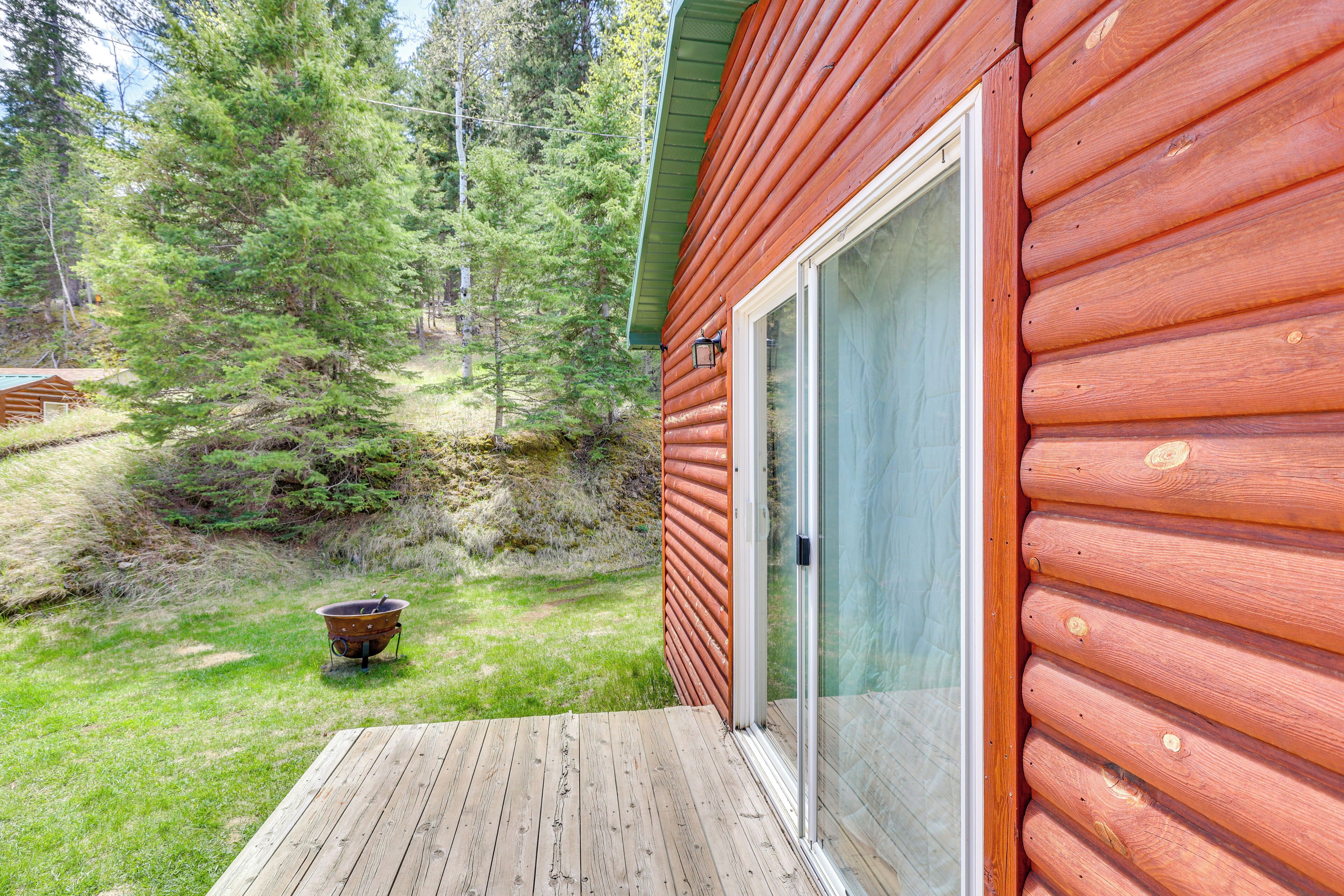 A wooden cabin with a glass door leading to a deck.