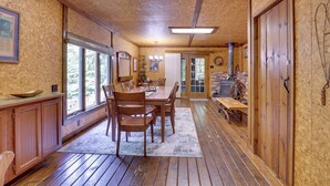 Interior de madera con comedor, armarios de madera y un ventanal grande.