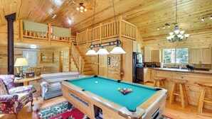 A wooden cabin interior with a pool table, a sofa, a dining area, and a kitchen. - Hike, Unwind & Bring Your Pet: Deadwood Cabin! (Deadwood)
