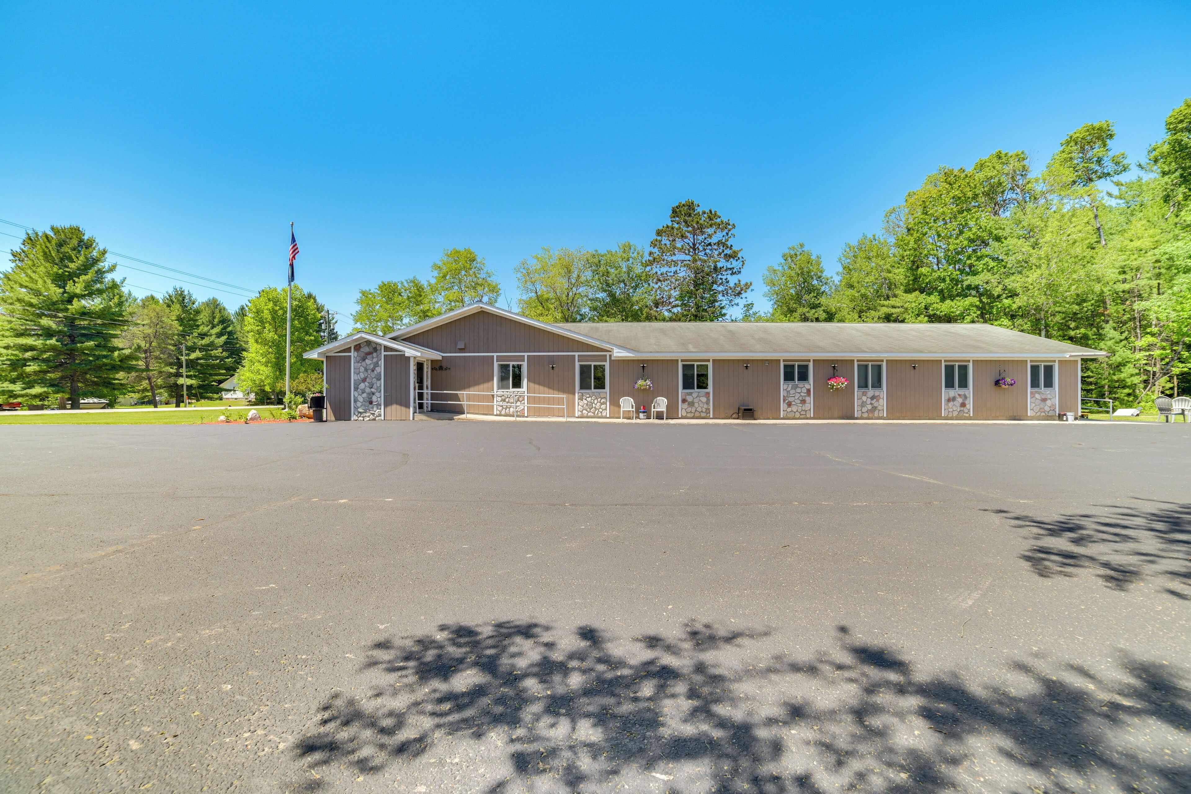 A single-story building with a flat roof, a front entrance, and a parking lot in front.