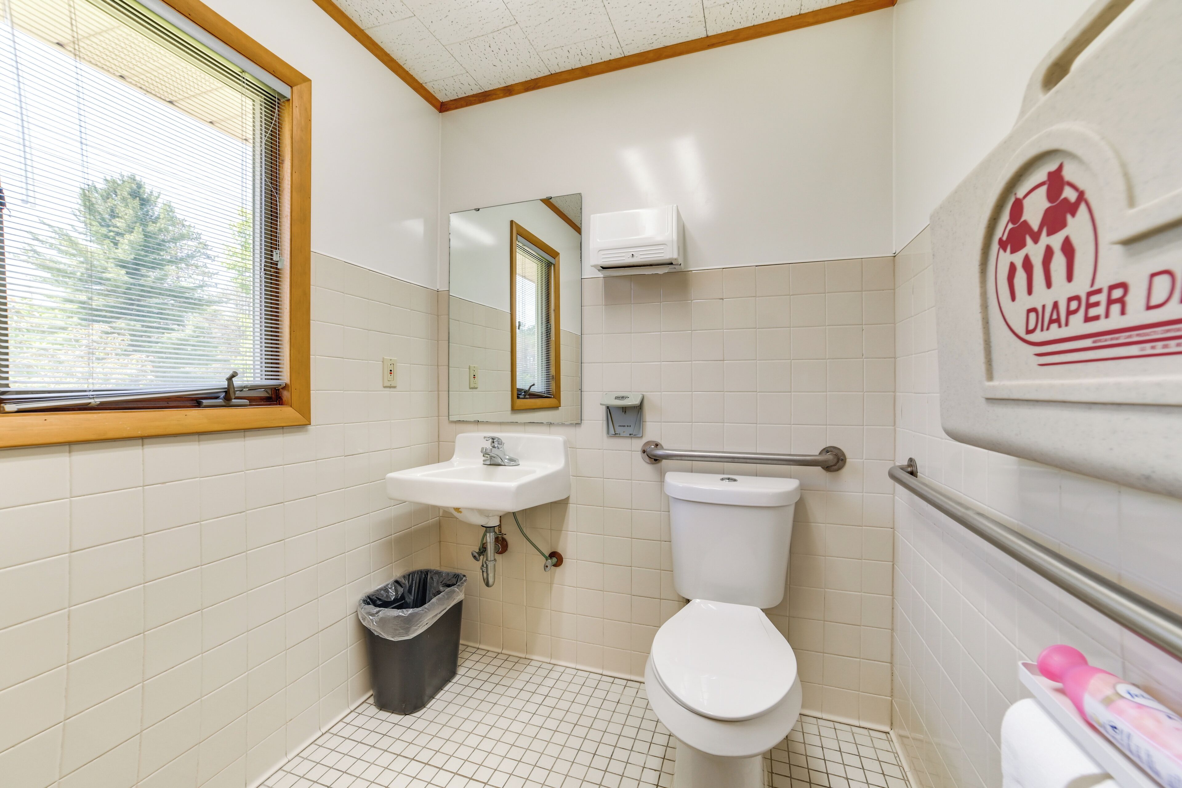 Ein kleines, sauberes Badezimmer mit Toilette, Waschbecken und Fenster.