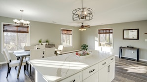 A modern kitchen with a large island, white cabinetry, and a ceiling fan. - Winter Linden Escape: Family Home & Gym (Linden)