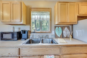 A kitchen with wooden cabinets, a double sink, a microwave, and a coffee maker. - Hiking Trail On-site: Mtn-view Eagle Point Retreat (Ashland)