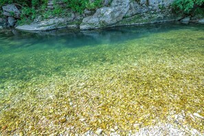 A clear river with visible pebbles and a rocky bank. - Secluded Vacation Rental Bordering Creek! (Mountain View)