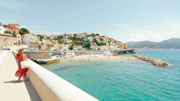 A coastal town with a beach, a pier, and buildings on a hillside. - A DAY AT LA VILLA BOMPARD: RELAXATION AND ADVENTURE AWAIT (Marseille)