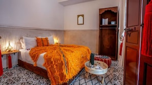 Une pièce comprenant un lit, une table de chevet, une petite table, une armoire et une porte.