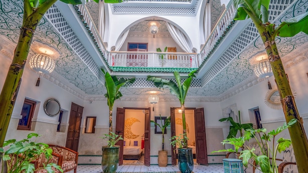 Un intérieur luxueux avec une piscine centrale, un plafond richement décoré et un mobilier de style traditionnel.