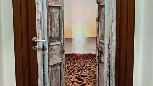 A door leading to a beach room with a view of the sunset. - A casa di Peppe (Palermo)