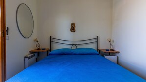 A bedroom with a bed, a wall-mounted mirror, a small wooden sculpture, and bedside tables with lamps. - 3980 Villino Silvana By Barbarhouse (Lecce)