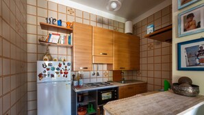 A compact kitchen with wooden cabinets, a refrigerator with magnets, a microwave, and a sink. - 3980 Villino Silvana By Barbarhouse (Lecce)