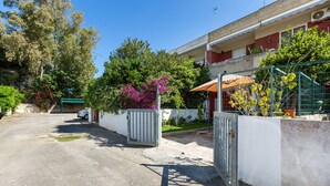 A residential street with a gated entrance, a parked car, and a building with a balcony. - 3980 Villino Silvana By Barbarhouse (Lecce)