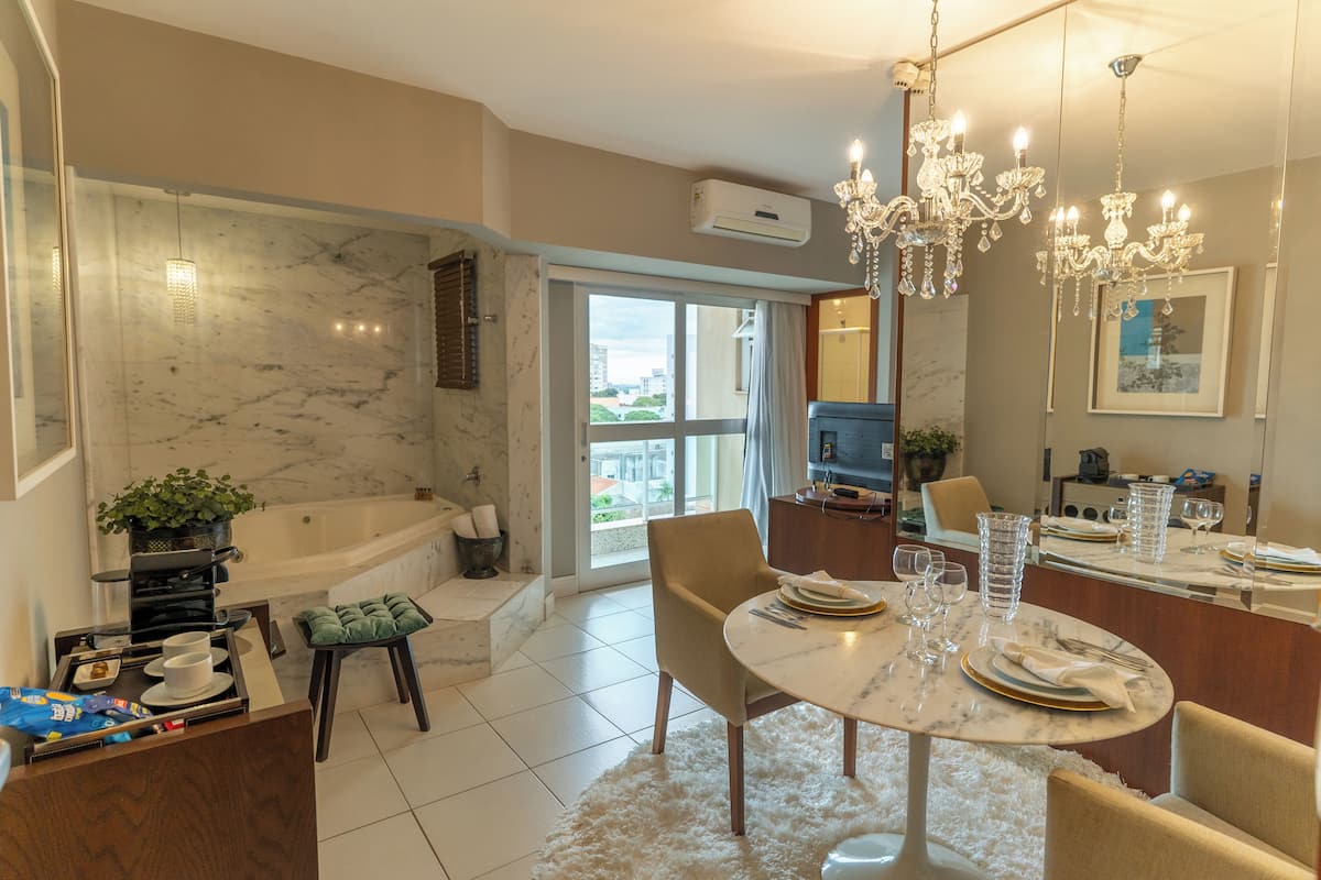 A modern kitchen with a marble countertop, a built-in oven, and a coffee machine.