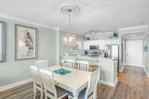 Una cucina moderna con mobili bianchi, un frigorifero in acciaio inossidabile e un forno a microonde integrato.