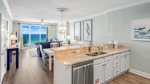 A modern kitchen with a large island, stainless steel appliances, and a view to the outside. - Ocean Reef 1005 Beachfront, Heated Indoor & Outdoor Pools, Hot Tub, FREE Golf (Panama City Beach)